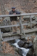 Hispanic man relaxing on footbridge