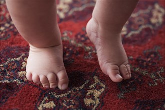 Feet of Hispanic baby boy on carpet