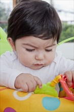 Hispanic baby boy playing with toy