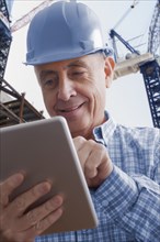 Hispanic construction worker using digital tablet