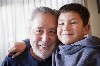 Hispanic grandfather and grandson hugging