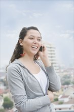 Hispanic woman talking on cell phone outdoors