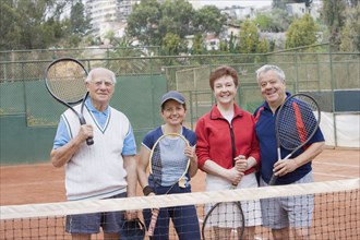 Senior Hispanic couples playing tennis