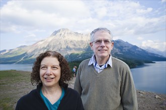 Caucasian couple standing outdoors with mountain in background