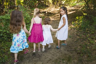 Caucasian girls walking on forest path