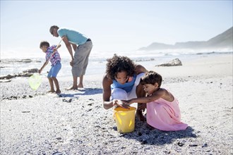 Mixed race family playing on beach