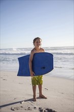Caucasian by carrying boogie board on beach