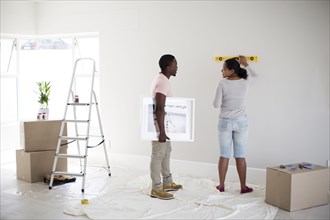 Couple using level in new home