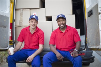Delivery men sitting with packages in van