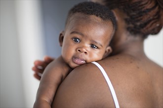 Close up of Black mother burping baby over her shoulder