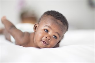 Close up of Black baby laying on bed