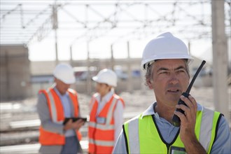Worker talking on walkie-talkie at construction site