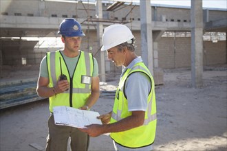 Caucasian construction workers talking at construction site