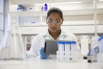 Mixed race scientist using digital tablet in laboratory