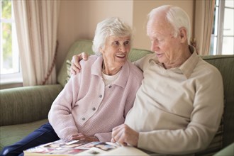 Older Caucasian couple looking at photo album