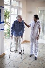Nurse talking to patient using walker