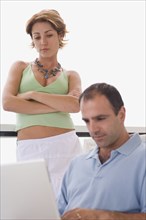 Man using laptop while woman watches