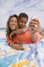 Mother and son taking self portrait on the beach