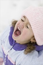 Young girl yelling in snowsuit outdoors