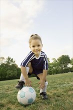 Young girl in athletic gear with soccer ball