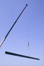 Crane holding steel beam