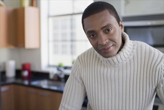 African man looking serious in kitchen