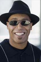 Close up of African man wearing sunglasses and hat
