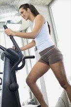 Hispanic woman exercising in health club