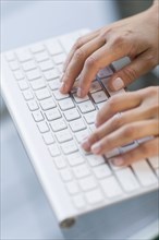 Close up of hands typing on computer keyboard