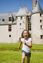 Hispanic girl running with castle in background