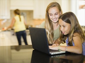 Hispanic girls using laptop together