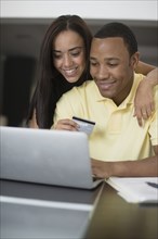 Mixed race couple shopping online with credit card