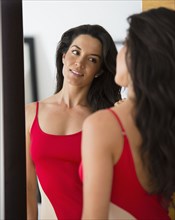 Hispanic woman looking at her reflection