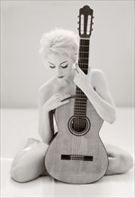 Nude Cuban woman holding guitar