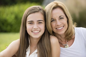 Caucasian mother and daughter smiling outdoors