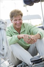 Caucasian man sitting on sailboat