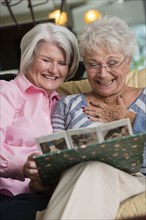 Senior Caucasian women looking at photo album