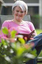 Senior Caucasian woman using digital tablet outdoors
