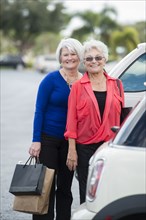Senior Caucasian women with shopping bags in parking lot