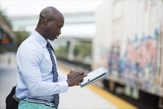 African American businessman waiting for train