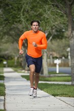 Caucasian man jogging on suburban street