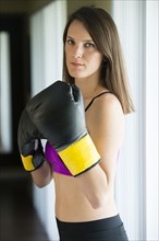 Caucasian woman with boxing gloves raised