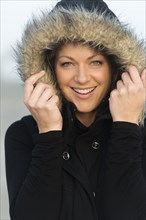 Caucasian woman wearing coat with fur hood outdoors