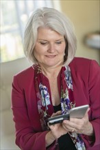 Caucasian older woman shopping online with cell phone