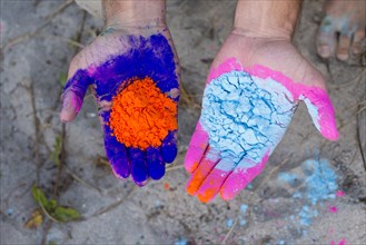 Caucasian man holding colorful paint powder