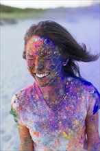 Caucasian woman splattered with paint powder with eyes closed