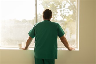 Caucasian nurse looking out window