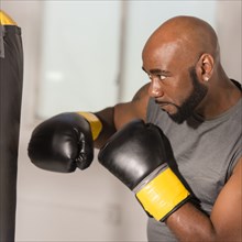 Black boxer training with punching bag