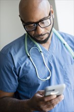 Black nurse using cell phone