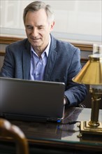 Caucasian businessman working on laptop at desk